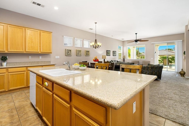 kitchen with a kitchen island with sink, light carpet, white dishwasher, ceiling fan with notable chandelier, and sink