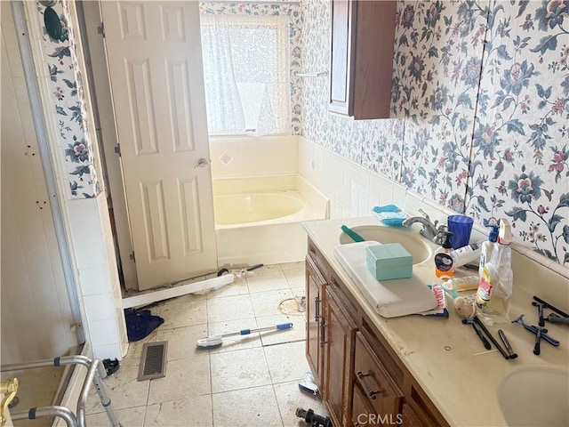 bathroom with a bathing tub, tile patterned flooring, and vanity