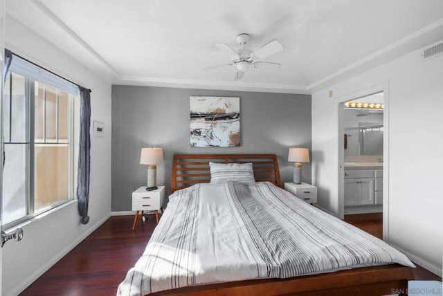 bedroom with ensuite bath, dark wood-type flooring, and ceiling fan