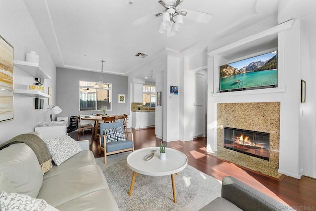 living room featuring hardwood / wood-style floors, a high end fireplace, and ceiling fan