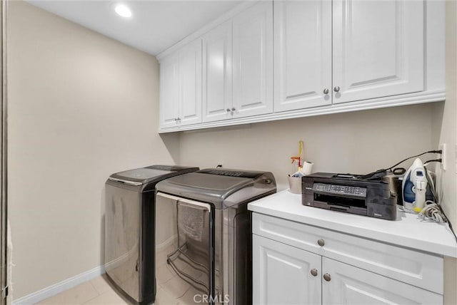 laundry area featuring light tile patterned flooring, cabinets, and washing machine and clothes dryer