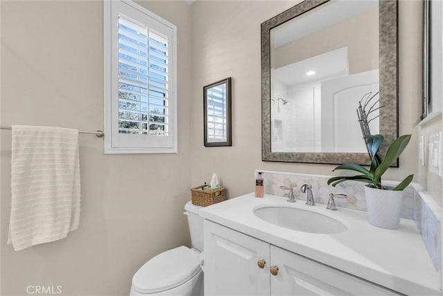 bathroom featuring walk in shower, vanity, and toilet