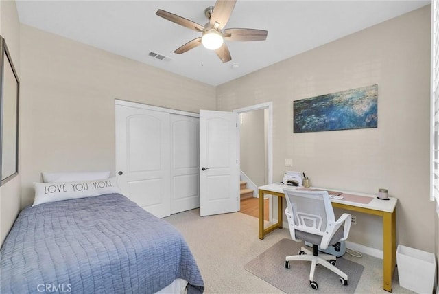 bedroom with a closet, light colored carpet, and ceiling fan