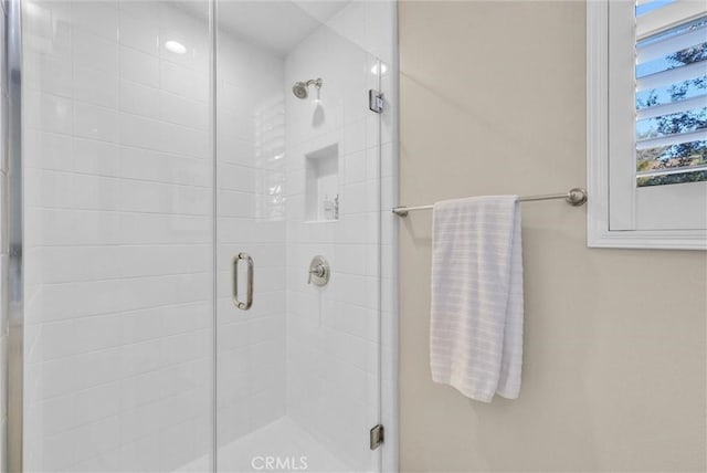 bathroom featuring a shower with shower door