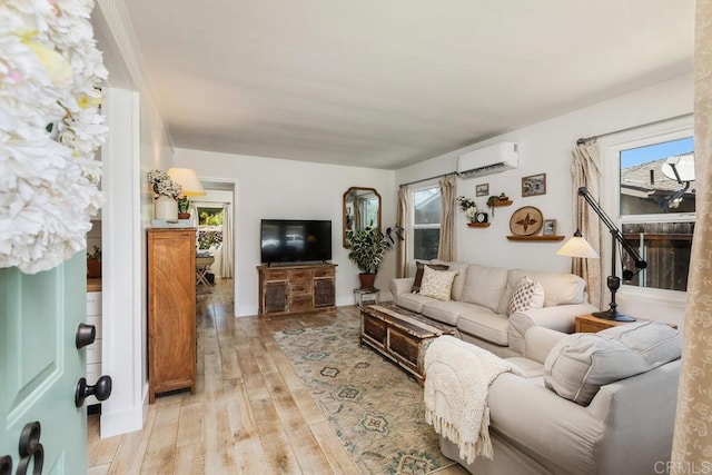 living room featuring a healthy amount of sunlight, an AC wall unit, and light hardwood / wood-style flooring