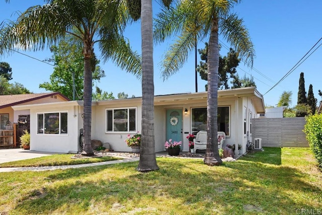 ranch-style house featuring fence, a front lawn, and stucco siding