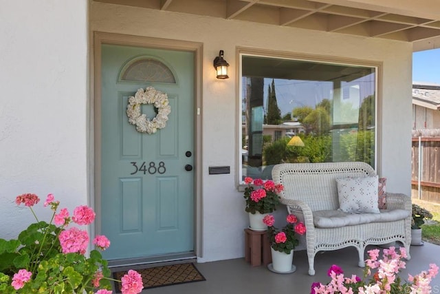 entrance to property featuring stucco siding and a porch