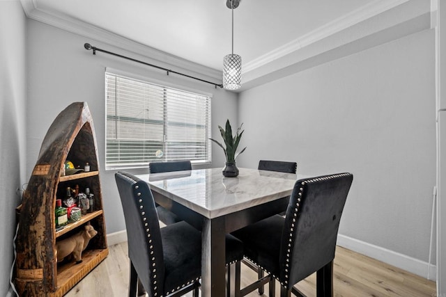 dining space with light wood-type flooring and crown molding