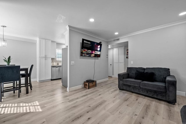 living room featuring light hardwood / wood-style flooring and crown molding