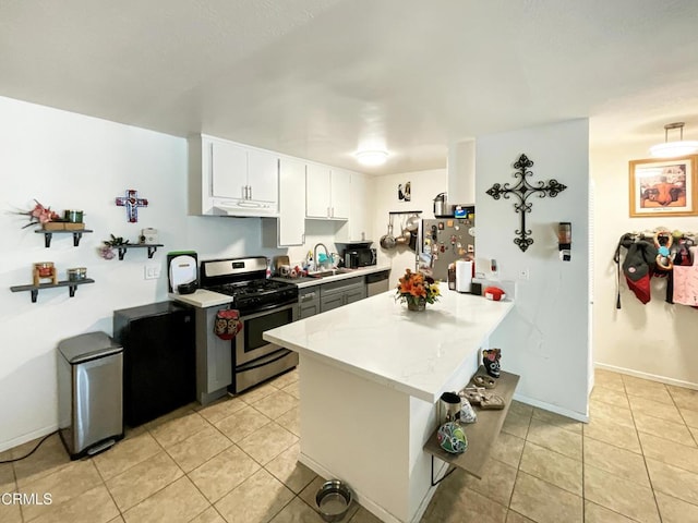 kitchen featuring light tile patterned floors, kitchen peninsula, appliances with stainless steel finishes, and white cabinetry