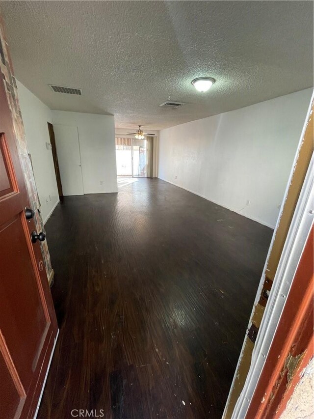 empty room featuring hardwood / wood-style flooring, ceiling fan, and a textured ceiling