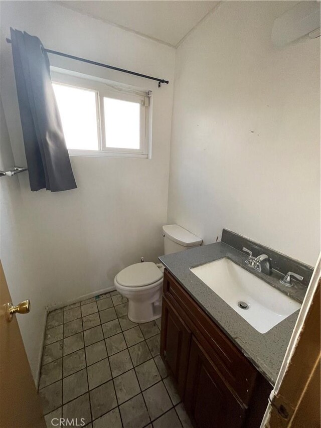 bathroom featuring vanity, tile patterned floors, and toilet