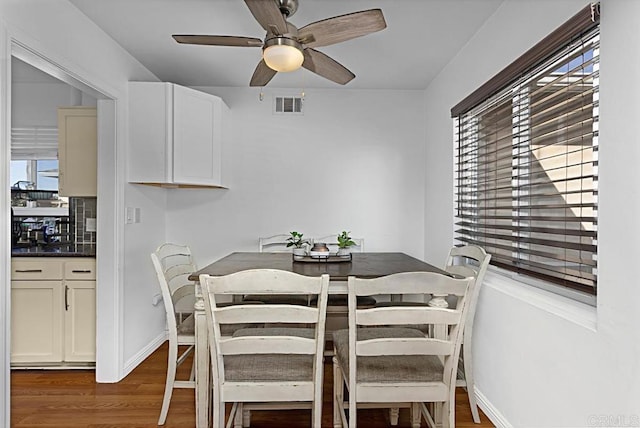 dining room featuring ceiling fan, plenty of natural light, and dark hardwood / wood-style flooring