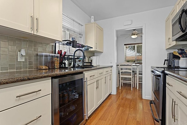 kitchen featuring wine cooler, appliances with stainless steel finishes, backsplash, and dark stone countertops