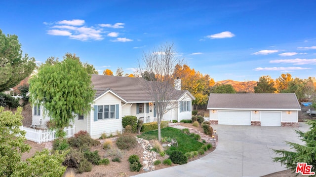 single story home featuring a mountain view, a garage, and an outdoor structure