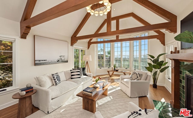 living room featuring beam ceiling, light wood-type flooring, and high vaulted ceiling