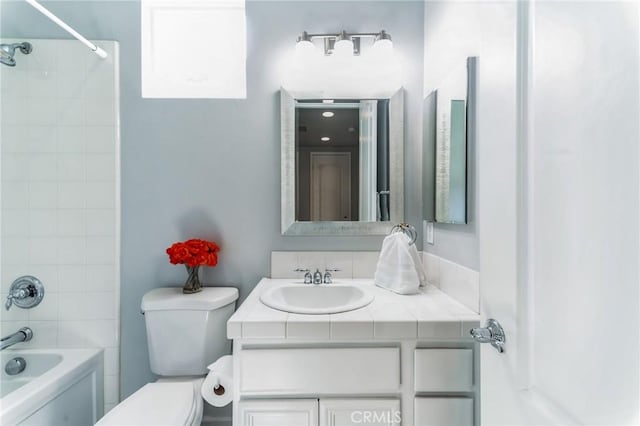 full bathroom with toilet, vanity, and tiled shower / bath combo