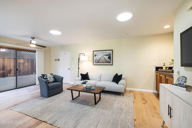 living room featuring ceiling fan and light hardwood / wood-style floors