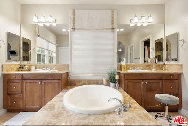 bathroom featuring vanity and tiled bath