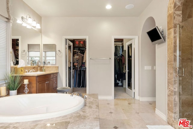 bathroom featuring tile patterned flooring, shower with separate bathtub, and vanity