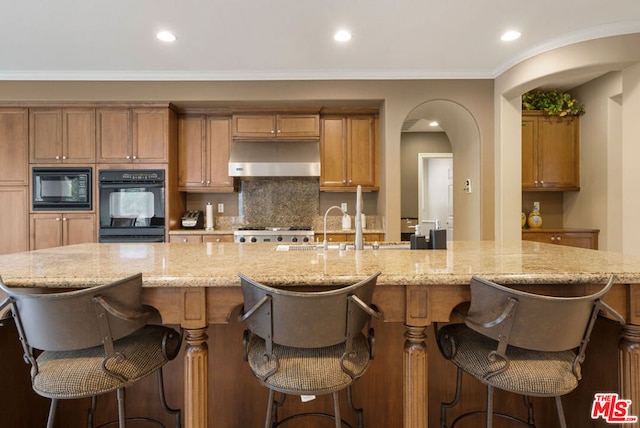 kitchen featuring a large island, a breakfast bar area, and black appliances