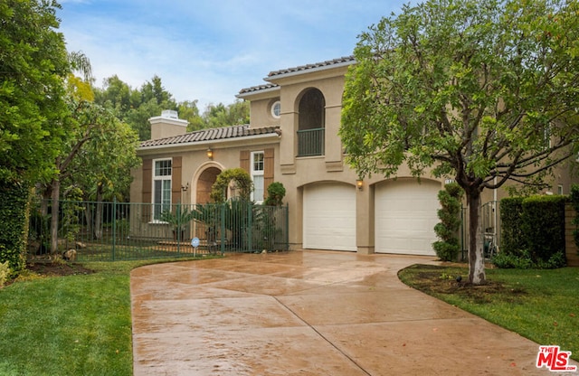 mediterranean / spanish home featuring a front yard and a garage