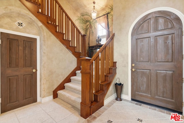 tiled foyer entrance featuring a towering ceiling