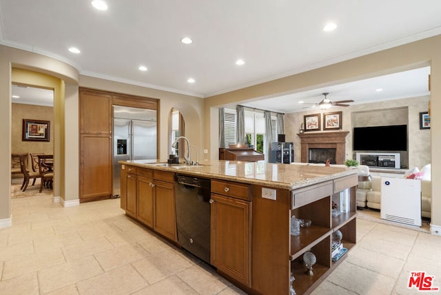 kitchen featuring ceiling fan, sink, black dishwasher, built in refrigerator, and a center island with sink