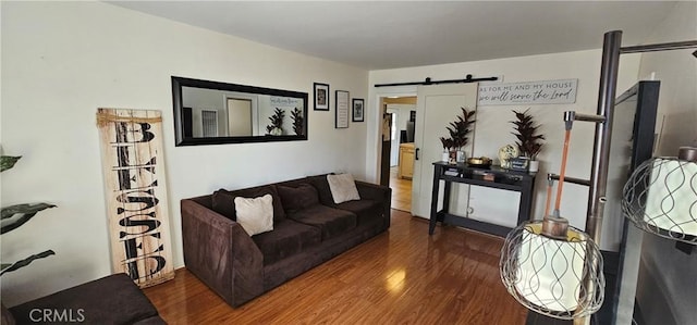 living room with a barn door and dark hardwood / wood-style floors