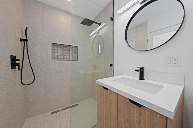 bathroom featuring vanity and tiled shower