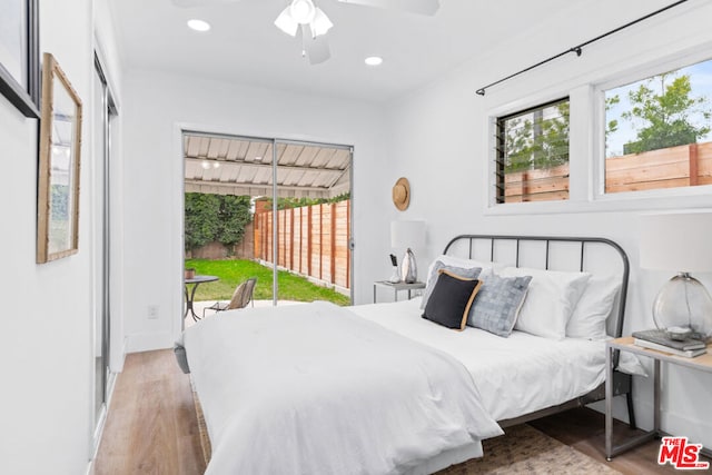 bedroom featuring access to outside, hardwood / wood-style flooring, and ceiling fan