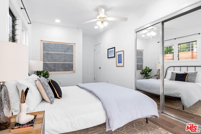 bedroom featuring a closet, dark hardwood / wood-style floors, ceiling fan, and crown molding