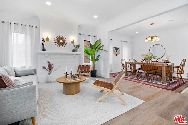 living room featuring wood-type flooring and an inviting chandelier