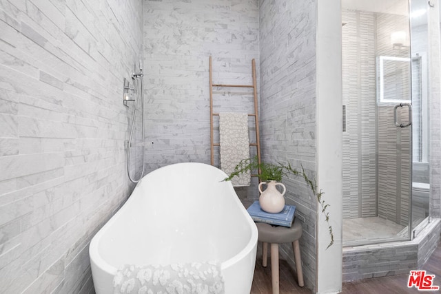 bathroom featuring separate shower and tub and hardwood / wood-style flooring