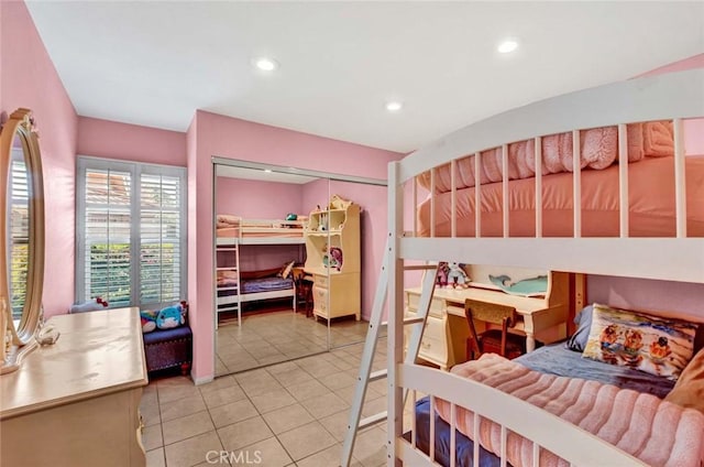 bedroom with tile patterned floors and a closet