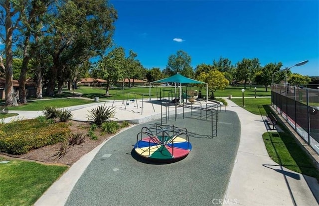 view of community featuring a playground and a lawn