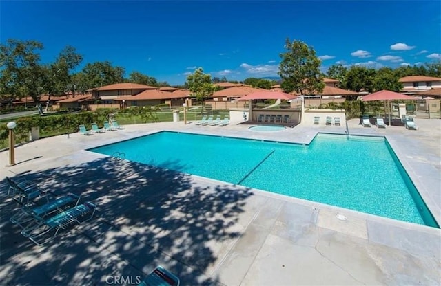 view of swimming pool with a patio area and a hot tub