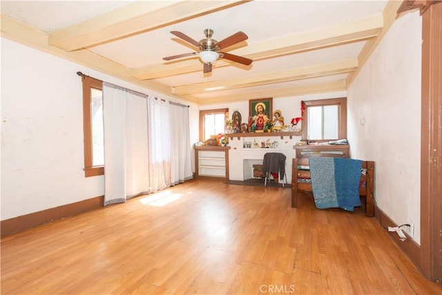 unfurnished office with ceiling fan, beam ceiling, and light hardwood / wood-style floors