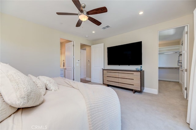 carpeted bedroom with ceiling fan, a walk in closet, and a closet