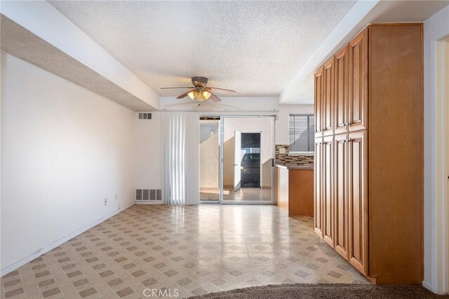 interior space with ceiling fan and a textured ceiling