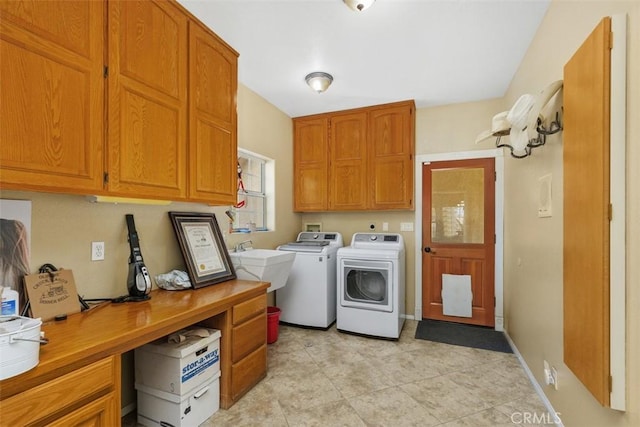 clothes washing area with cabinets, washer and clothes dryer, and sink