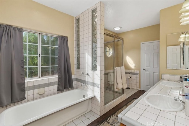 bathroom with tile patterned flooring, separate shower and tub, and vanity