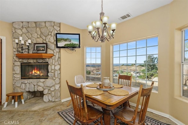 dining space with a fireplace and an inviting chandelier