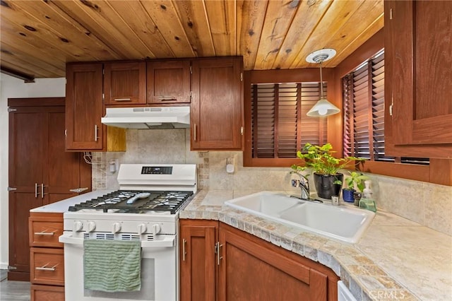 kitchen with sink, gas range gas stove, wooden ceiling, pendant lighting, and backsplash