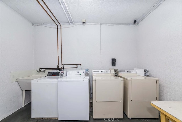 laundry room featuring washing machine and clothes dryer and a textured ceiling