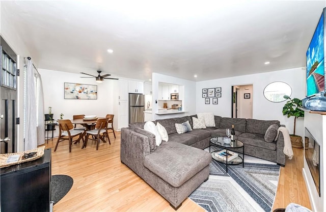 living room featuring light hardwood / wood-style flooring and ceiling fan