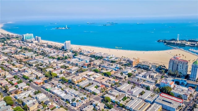 birds eye view of property with a water view and a beach view