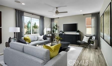 living room with ceiling fan and light hardwood / wood-style flooring