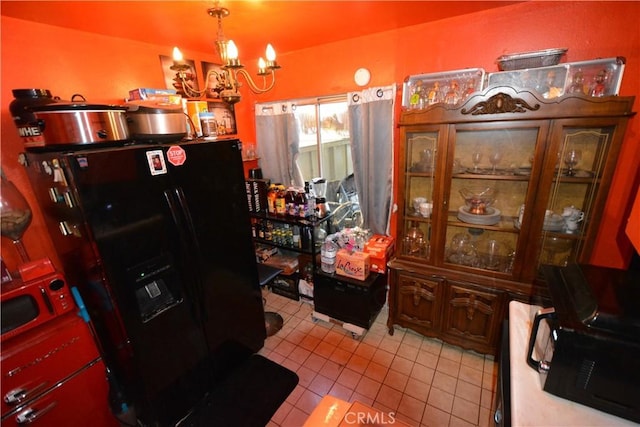 kitchen featuring black refrigerator with ice dispenser, light tile patterned flooring, a chandelier, and decorative light fixtures