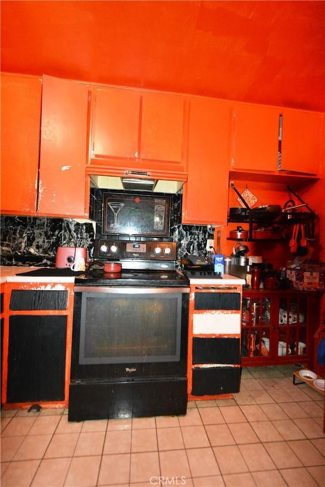 kitchen with decorative backsplash, light tile patterned floors, and black / electric stove